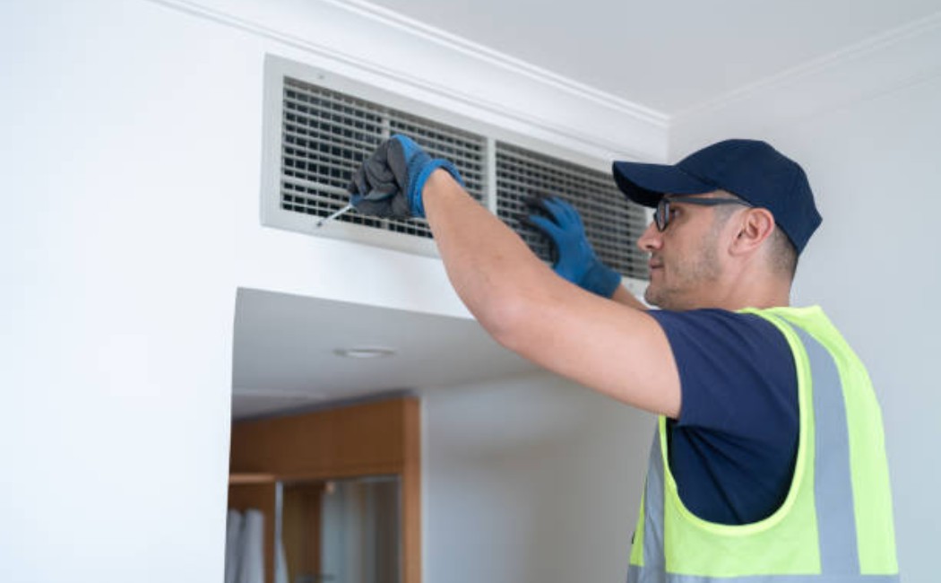 Repairman offering Appliance Installation Services and cleaning the air grille