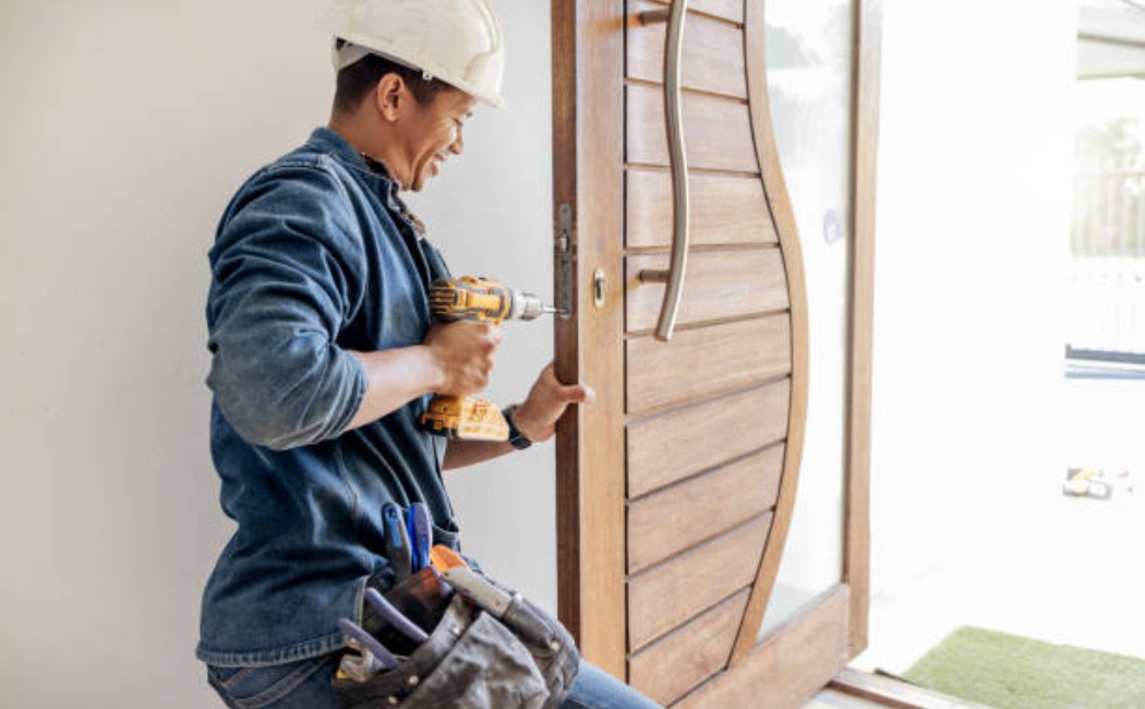 Handyman repairing the lock on the residential door