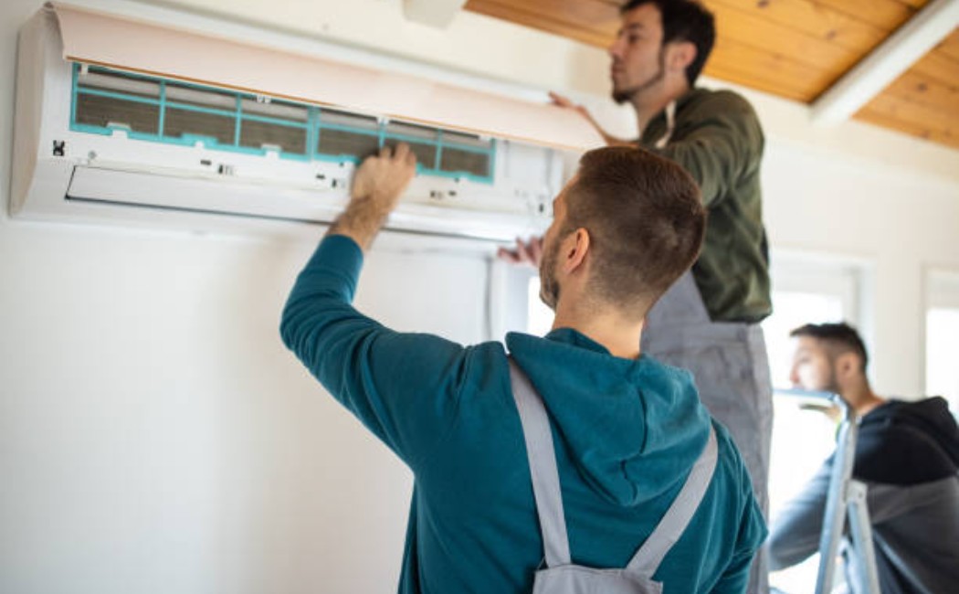 Two repairmen fitting a residential air conditioning system