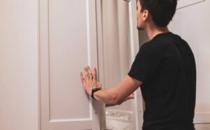 istockphoto-2228964290-612x612_1050x650_q90 Male closing closet doors in a clean bedroom setting.