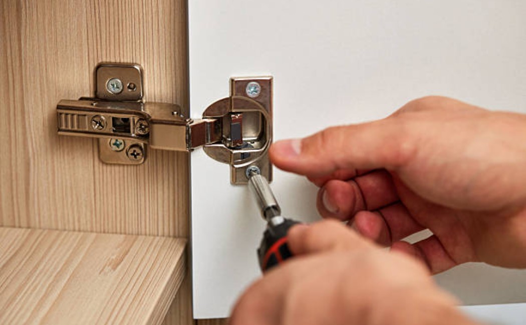 Cabinet door hinge adjustment by a handyman.